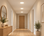 Drei runde LED Einbaupanels mit warmweißem Licht, mittig entlang einer modernen Flurdecke angeordnet.