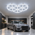 LED Hexagon Set mit 14 Lichtsegmenten und 6500 K über einer grauen Limousine ohne Emblem in der Garage